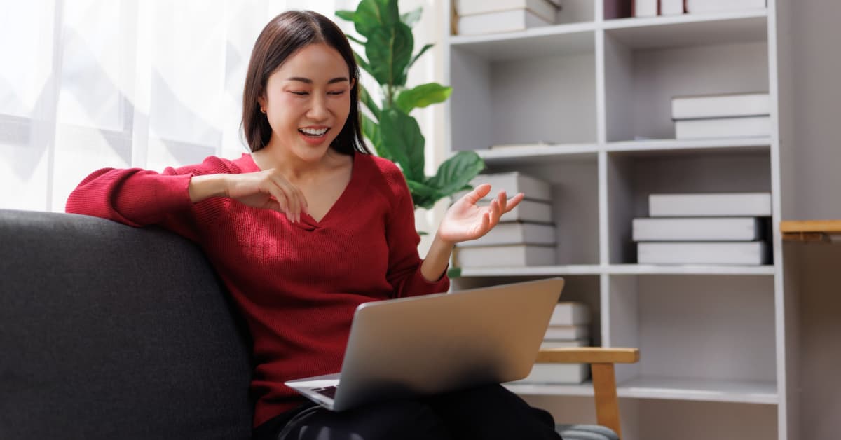 woman in a red sweater taking a zoom call with a dietitian in her home