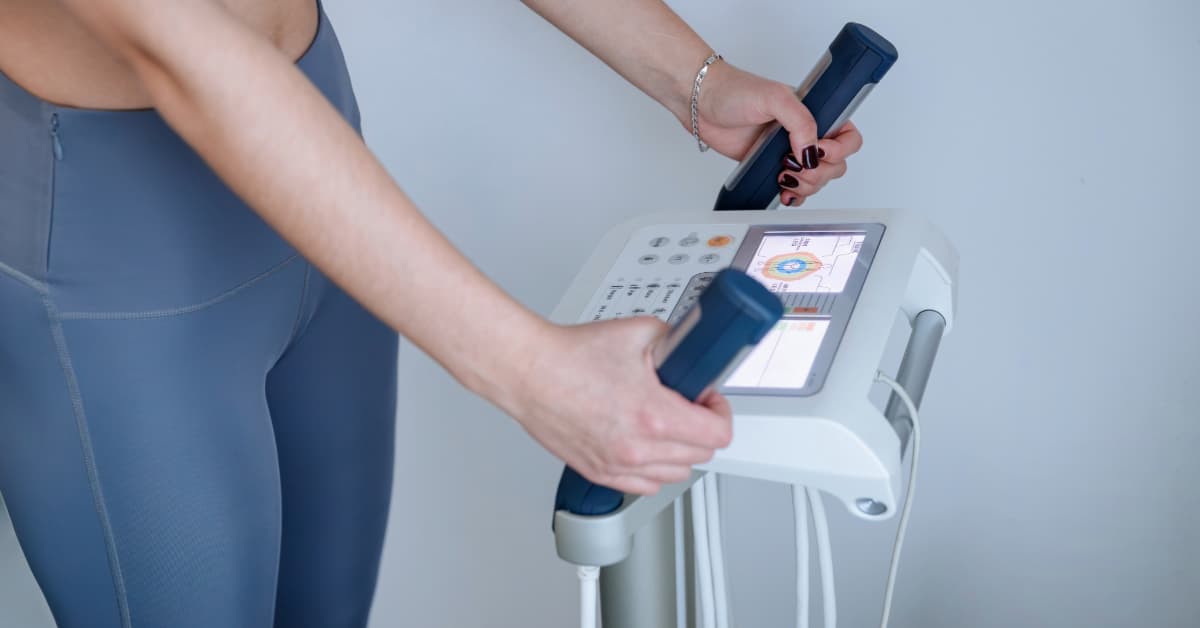 a woman in athletic clothing using an InBody scanners for body composition results
