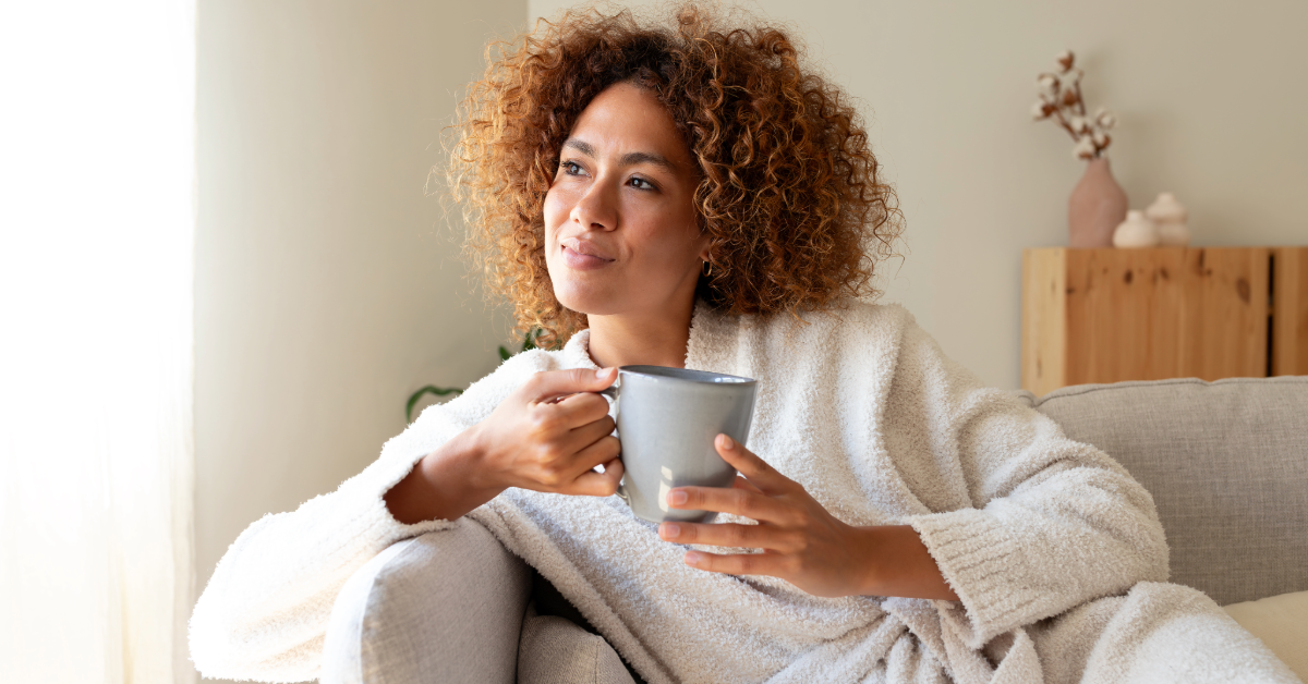 woman holding a coffee cup looking into the distance 