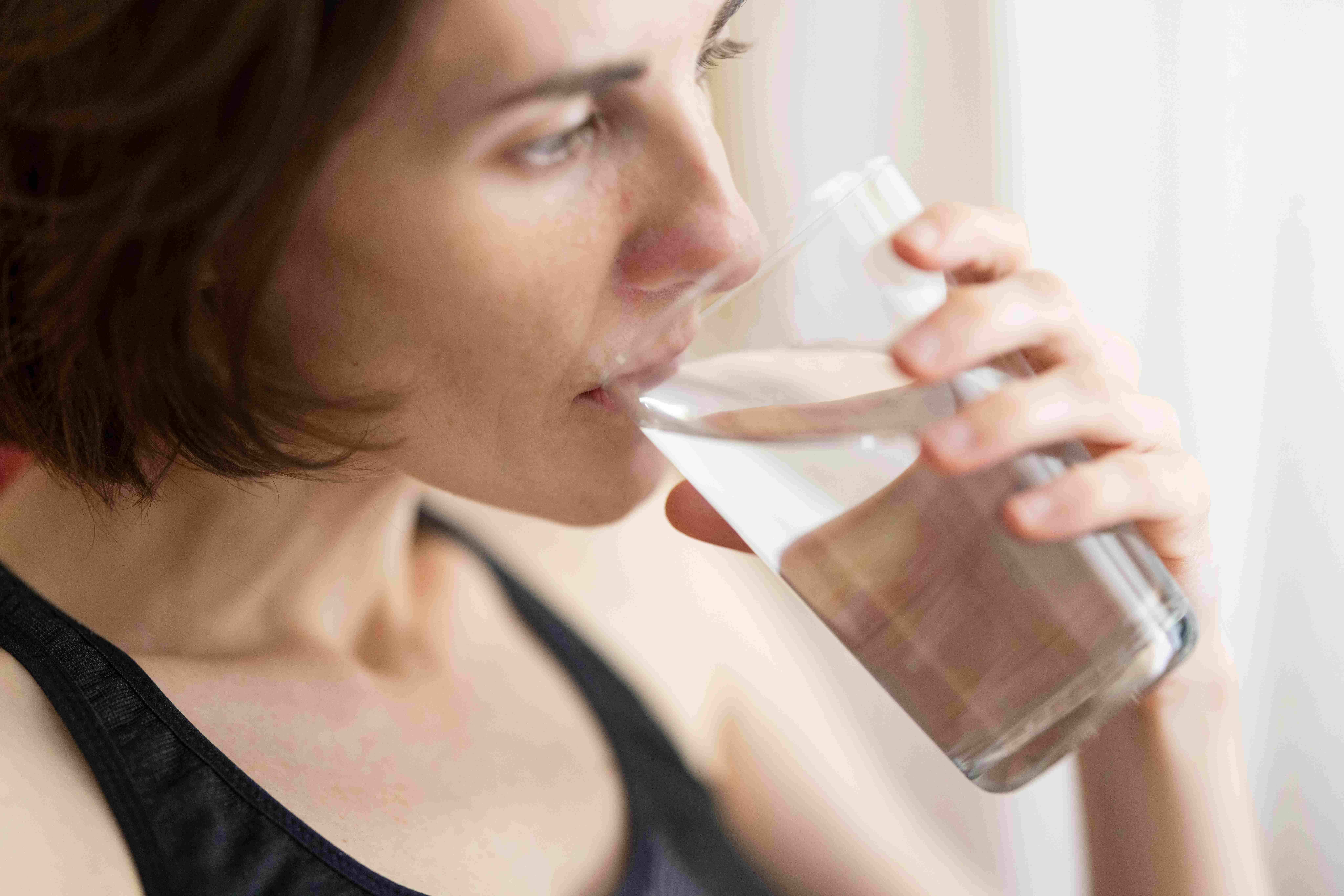 woman drinking water while fasting 