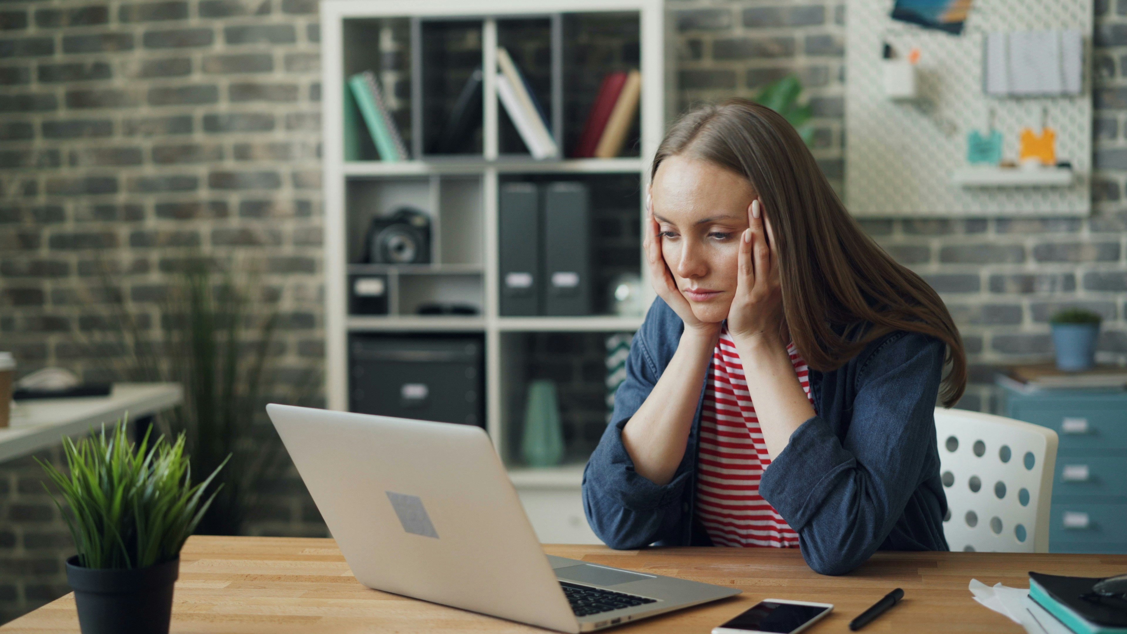 woman with chronic fatigue working on a laptop 